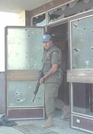 Canadian UN soldier searching for small arms.